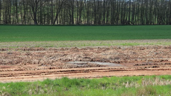 Der rot-braun gefärbte Schlamm auf dem Feld ärgert die Anwohner im Begatal. - © Tobias Schneider