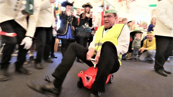 Unter dem Jubel der Gäste muss Steinheims Bürgermeister Carsten Torke Bobby-Car durchs Rathaus fahren. - © David Schellenberg