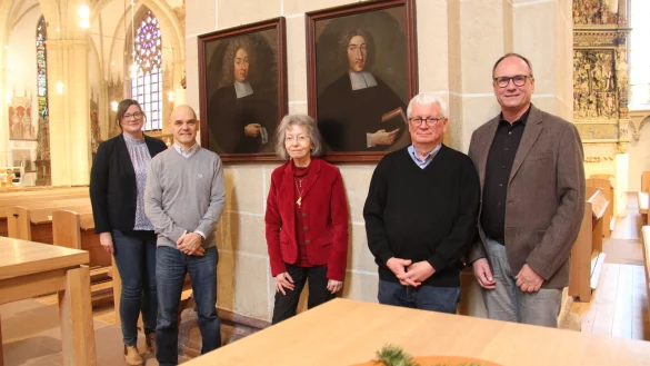 Julia Kathke (von links) vom NHV, Designer Martin Emrich, die ehemalige Lemgoer Stadtarchivarin Gisela Wilbertz, der ehemalige Lemgoer Museumsleiter Jürgen Scheffler und Superintendent Dr. Andreas Lange vor den Porträts der ehemaligen Pfarrer Johann Barthold Haccius (links) und wahrscheinlich Andreas Haccius in der Kirche von St. Nicolai. - © Nadine Uphoff