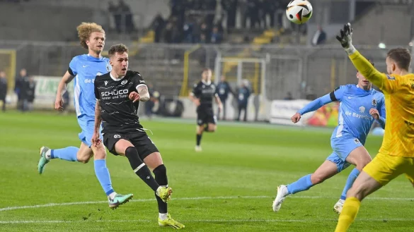 Joel Grodowski hebt den Ball &uuml;ber L&ouml;wen-Keeper Marco Hiller hinweg zur Bielefelder F&uuml;hrung ins Tor des TSV 1860. - &copy; IMAGO/Sven Simon