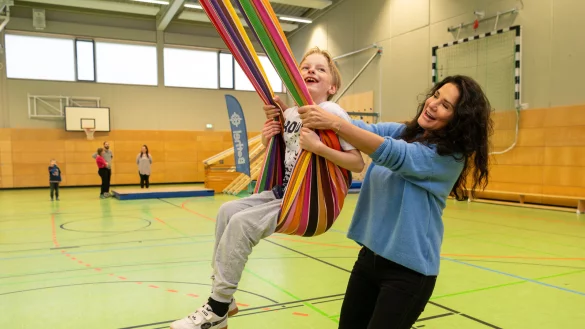 Schauspielerin Mariella Ahrens ist zu Gast in der Topehlen-Schule, hier gibt sie in der Sporthalle Noah Anschwung beim Schaukeln. - &copy; Christian Weische/Bethel