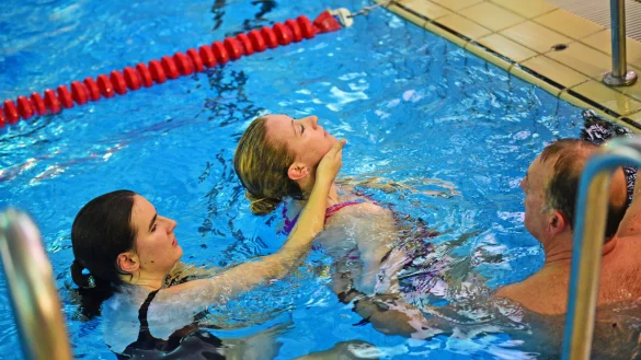 Manfred Krumsiek erkl&auml;rt Chiara Wibbeke (links), wie das Schleppen einer zu rettenden Person funktioniert. Melina Schau simuliert dabei die zu rettende Person. - &copy; Nicole Ellerbrake