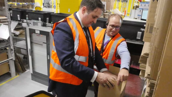 NRW-Europaminister und Chef der Staatskanzlei Nathanael Liminski (links) l&auml;sst sich vom Beller Amazon-Standortleiter Ren&eacute; Hille das Verpacken zeigen. - &copy; Jost Wolf