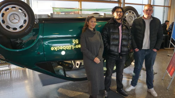 Drei Auszubildende zu Kaufleuten im Groß- und Außenhandel stehen vor dem Überschlagssimulator im Hanse-Berufskolleg. - © Fotorechte: Hanse Berufskolleg