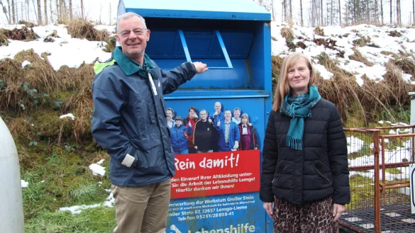 Axel Mayer von der Abfallbeseitigungsgesellschaft und Regine Lükermann vom Abfallwirtschaftsverband zeigen einen Altkleider-Container auf dem Recyclinghof an der Maibolte. - © Nadine Uphoff