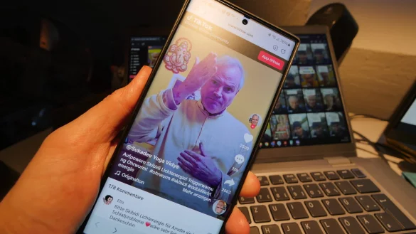 Mit Skibidi-Clips ist Sukadev Bretz derzeit sehr produktiv. Auf seinem TikTok-Kanal (im Hintergrund) sind hunderte Kurzvideos zu sehen, in denen der Yoga-Vidya-Leiter die Segensbitten - auch von vielen Schülern - erfüllt. - © Jost Wolf