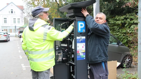 Uwe Neuber (links) von der Firma PSG und Mycahit H&uuml;lk&uuml; von den Stadtwerken Lemgo bauen den ersten neuen Parkscheinautomaten am Parkplatz Neues Tor auf. - &copy; Nadine Uphoff