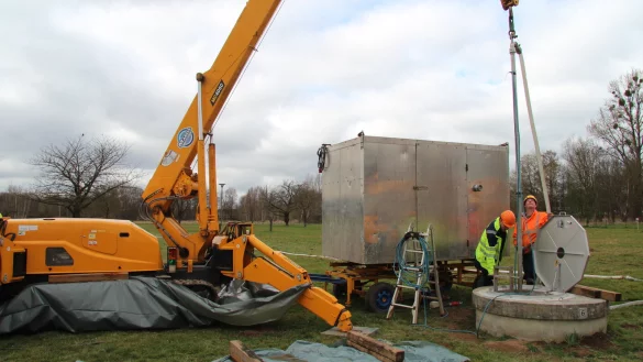Björn Hagemann von den Stadtwerken Lemgo (links) und Lucas Mautner von der Firma Eugen Engert stehen an einem der Brunnen auf den Braker Wiesen, die derzeit kontrolliert werden. - © Nadine Uphoff
