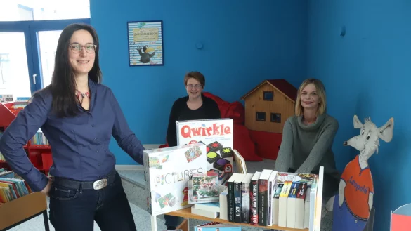 Gemeindeb&uuml;cherei-Leiterin Kerstin Koppmann (von links), Kerstin Proepper und Bettina Bertling in der Kinderecke mit dem Wagen, auf dem die neuen B&uuml;cher und Medien stehen, die sich B&uuml;rger gew&uuml;nscht haben.&nbsp; - &copy; Birgit Guhlke
