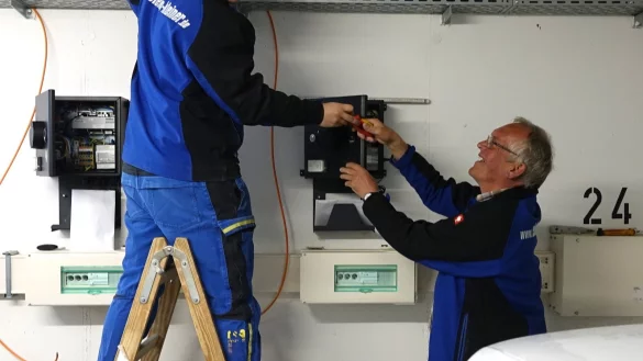 Die Elektriker Joschua Hark (links) und Bernd Osburg bei der Installation der Wallboxen in der Tiefgarage der Werreterrassen. - &copy; Axel B&uuml;rger