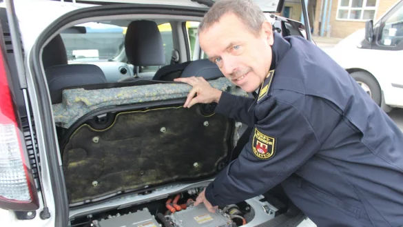Motor im Kofferraum: Bernd Heißenberg, Branddirektor bei der Bielefelder Berufsfeuerwehr, zeigt den Motor eines Peugeot iOn, der im Heck verbaut ist. Besonders gefährlich für Retter sind jedoch die Akkus, die sich meist im Unterboden befinden. - © Franz Purucker