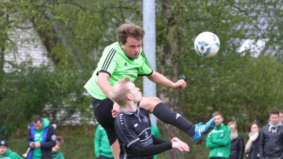 Luftkampf am Sportker Holz: Torsten Petri überspringt den Helpuper Felix Knaup. - © Jörg Hagemann.