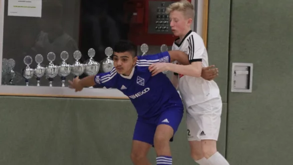 Schirmt das Leder gekonnt vor dem Gegenspieler ab: Der Bad Salzufler Jonas Mike Derbas (blaues Trikot) bei der Partie gegen den SC Verl. Im Hintergrund sind die ganzen Pokale aufgereiht. - &copy; Sebastian Lucas