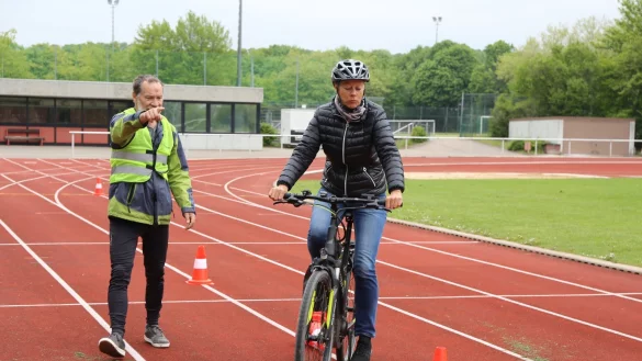 Langsam fahren: Britta Lindner-Kirchner beherrscht den Slalomparcours schon ziemlich gut. Rolf P&uuml;hse vom Radsportverein Knetterheide zeigt, wo es weiter zur Station f&uuml;r die Gefahrenbremsung geht.&nbsp; - &copy; Alina Hetland