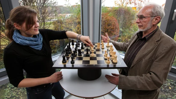 Herausforderung in schwarz und weiß: Jugendschachwart Wilhelm Henjes erklärt LZ-Volontärin Janet König die Grundzüge des Schachspiels. Im Bild wird gerad eine Eröffnungssituation dargestellt. - © Bernhard Preuss