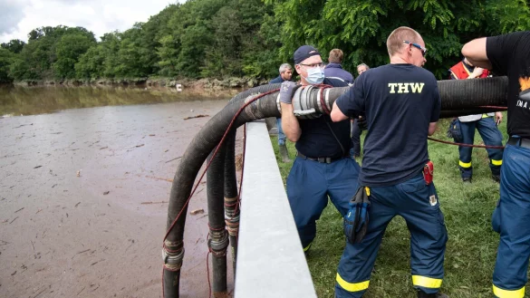 Helfer des Technischen Hilfswerks (THW) lassen Schl&auml;uche in die Steinbachtalsperre in Euskirchen hinab, um das Wasser abzupumpen. Der Damm der Talsperre droht einst&uuml;rzen. - &copy; Marius Becker/dpa