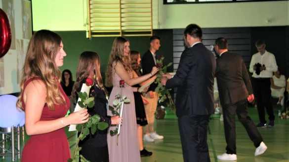 Die Abiturienten &uuml;berreichen ihrem (rechts) Stufenleiter Markus Riepe ein Geschenk. Rechts im Hintergrund ist Schulleiter Carsten Paul. - &copy; Julia Kube