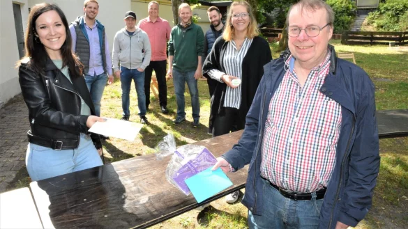 Kathrin Zimmermann (links) &uuml;berreicht Udo Heidsiek einen seiner drei gewonnenen Gutscheine. Mit ihm freuen sich (von links) Sch&uuml;tzenk&ouml;nig Sebastian Boer, Patrick Bockwinkel, Christian Landerbarthold, Sebastian Gna&szlig;, Fabian K&ouml;ster und Franziska H&ouml;hne auf dem Sch&uuml;tzenplatz.&nbsp; - &copy; Karin Prignitz