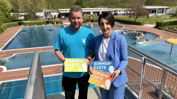 Marco Schubert (stellvertretender Betriebsleiter) und Anna-Lisa Davidovic (Abteilungsleiterin Unternehmenskommunikation Stadtwerke) stehen auf dem Sprungturm im Bega-Bad und zeigen das Design der neuen Saisonkarten. Foto: Sven Kienscherf - &copy; Sven Kienscherf