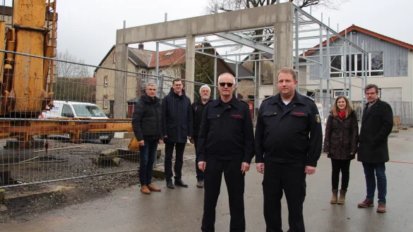 Mit dem Kran (links) entsteht die neue Fahrzeughalle. Dar&uuml;ber freuen sich (von links) Thorsten Paulussen, Matthias Kalkreuter, Andreas Naumann vom Geb&auml;udemanagement, Friedhelm St&ouml;lting, Andreas Bicker sowie Janina Fleischhammer und Thorsten Hoffjann vom Architekturb&uuml;ro Hoffjann. Rechts im Hintergrund ist das bestehende Ger&auml;tehaus zu sehen. - &copy; Nadine Uphoff