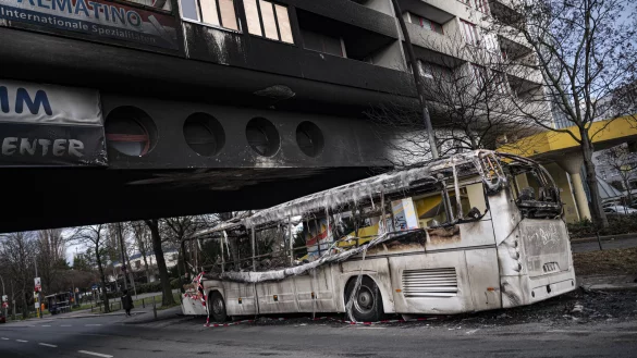 Ein ausgebrannter Reisebus steht nach Krawallen in der Silvesternacht vor einem besch&auml;digten Wohnhaus im Berliner Bezirk Neuk&ouml;lln. - &copy; Fabian Sommer
