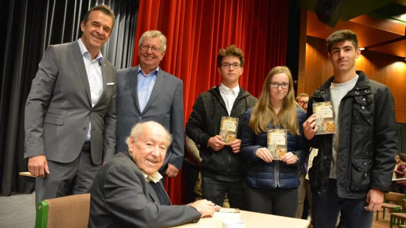 Autogramme: Sally Perel signiert Bücher für Mikail Bas, Nastassia Rzeczkowski und Maid Dück (von rechts). Dahinter stehen Rotary-Präsident Frank Krause (links) und Stefan Sudholt. - © Karin Prignitz