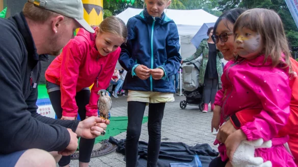 Unser Bild zeigt (von links) Tierpfleger Jonas Feist mit Mareen (11), Jana (10), Zijie Liao und Helen (3), die einen jungen Buntfalken anschauen. - &copy; Raphael Bartling