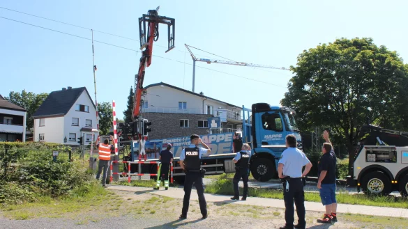 Mit vereinten Kräften befreien die Polizisten das Fahrwerk des Lkw aus der Oberleitung. - © Karolina Schmidt