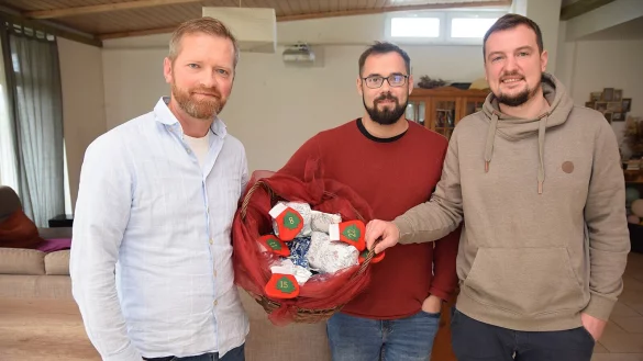 Eduard Henschel, Gabriel Schmid, Thomas Fain (v. l.) in dem Räumen der Wohngemeinschaft. In Händen halten sie einen Geschenkekorb, den eine Nachbarin jedes Jahr vorbeibringt, weil sie die Arbeit des Vereins schätzt. Foto: Karin Prignitz - © Karin Prignitz