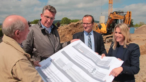 Ein gro&szlig;er Plan f&uuml;r ein Gro&szlig;projekt: (von links) Bau-Manager Rainer Joswig, Architekt Christoph Brune, Stadtwerke-Chef Arnd Oberscheven sowie Bauleiterin Britta Kwast von Goldbeck auf der Baustelle f&uuml;r das Campus-Parkhaus. Der Bagger hebt die Fundament-Gr&auml;ben aus. - &copy; Till Brand