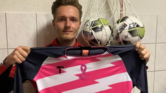 Das pink-wei&szlig;e Trikot mit der Schleife, die auf Brustkrebs aufmerksam macht, h&auml;lt Luc William Brunton in der Kabine des VfL in die Kamera. - &copy; Sebastian Lucas