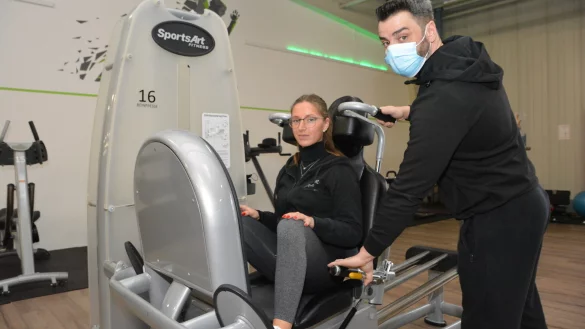 Anthony Watts mit seiner Auszubildenden Lea Wobig an der Beinpresse. Im Studio werden Stellen f&uuml;r Schnelltests weitergegeben. - &copy; Karin Prignitz