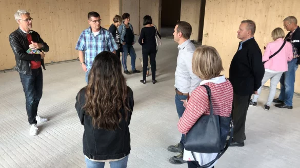 Ortsbegehung: Ronald Achtsnick (links) f&uuml;hrt die Mitglieder des Ortsausschusses Werl-Aspe durch den Neubau der Realschule. W&auml;nde und Decken der Lernh&auml;user sind auch innen komplett mit Holz ausgekleidet. Der Fu&szlig;boden muss noch gemacht werden. - &copy; Sven Kienscherf