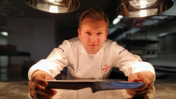 Auf seiner Kochjacke trägt Jan Diekjobst bereits den Michelin-Stern. Der 27-Jährige und sein Team in "Jan's Restaurant" im Detmolder Hof sind jüngst ausgezeichnet worden. Auf dem Kochmesser ist eine der wichtigsten Zutaten für den Weg zum Erfolg graviert: Leidenschaft. - © Yvonne Glandien