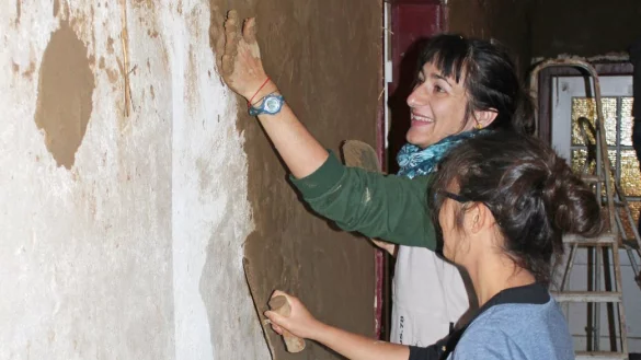 Internationale Unterstützung: Minh Tam Le (vorn) und Veronika Copkowa werken in den Rawaule- Innenräumen mit Lehm. - © Reinhold Sölter