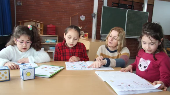 Mira, Natalia, Referendarin Agnieszka Stoellger und Delia schauen sich die selbst angefertigten W&ouml;rter-Schatzhefte an, in denen Dinge mit Hilfe von Bildern und W&ouml;rtern erkl&auml;rt werden. - &copy; Cordula Gr&ouml;ne