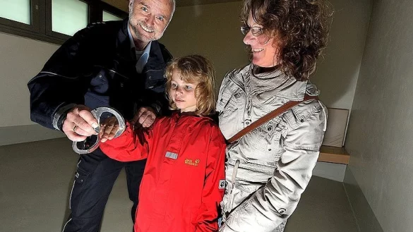 Der Bezirksbeamte Detlef Lippek zeigt in einer der gr&ouml;&szlig;ten Gewahrsamszelle der neunj&auml;hrigen Michelle Dittrich und ihrer Mutter Melanie seine Handschellen. Die neugierige Michelle steckt gleich mal eine Hand hindruch. - &copy; FOTOS: BARBARA FRANKE