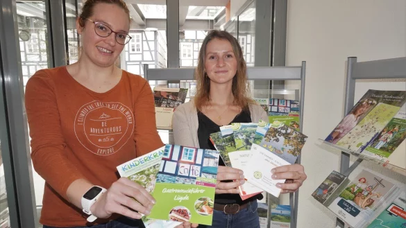 Larissa Gr&auml;bner (rechts) und Theresa G&ouml;rdes, Mitarbeiterinnen der Tourist-Information L&uuml;gde, zeigen die vielf&auml;ltige Auswahl an Brosch&uuml;ren und Flyern. Wanderkarten, Gastronomief&uuml;hrer und vieles mehr liegt im Foyer des Rathauses parat.&nbsp; - &copy; Michaela Weisse