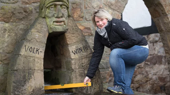 Denise Friedrich von der Tourist-Info prüft zum Spaß das märchenhafte und „bergauf laufende" Stadtwasser in Schwalenberg. Um sich die kleine Geschichte zu erhalten, sollten Besucher die Wasserwaage allerdings nicht zu genau anlegen. - © Foto: Torben Gocke