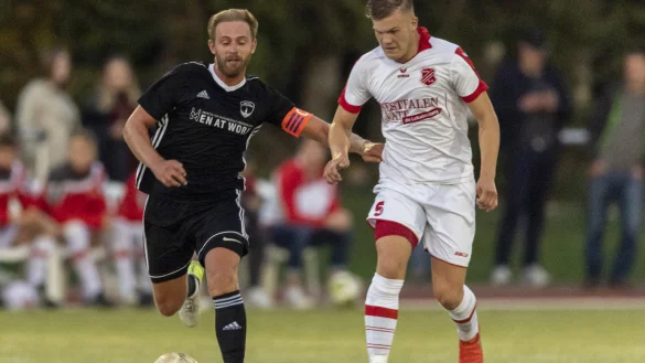 Zentrale - Der Postler Johann Felker(links, schwarz) und sein Steinhagener Kontrahent Jonas B&ouml;hme (wei&szlig;, rechts) im Laufduell um den Ball. Foto: Egon Penner. - &copy; Egon Penner