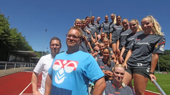 Vorfreude auf eine sicher spannende Saison: Der neue HSG-Trainer Steffen Birkner (im Vordergrund) und Manager Torben Kietsch (links) begrüßen die Blomberger Handballerinnen zum Trainingsauftakt. Rechts strahlt Physiotherapeutin Saskia Rodewald mit dem blauen Himmel im Stadion am Rammbocke um die Wette. - © Vera Gerstendorf-Welle