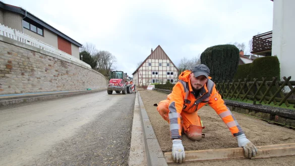 Valentino Perwan von der Firma Kemna arbeitet am Gehweg der Hohenhauser Stra&szlig;e. Links im Bild: ein Teil der St&uuml;tzmauer. - &copy; Jens Rademacher