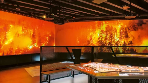 Klimaereignisse können in der Klimaerlebniswelt spürbar miterlebt werden. Wenn auf der Leinwand ein Waldbrand tobt, wird es auch im Raum erheblich wärmer. Nach einigen Minuten setzt dann wieder eine Abkühlung ein. - © Red Dot