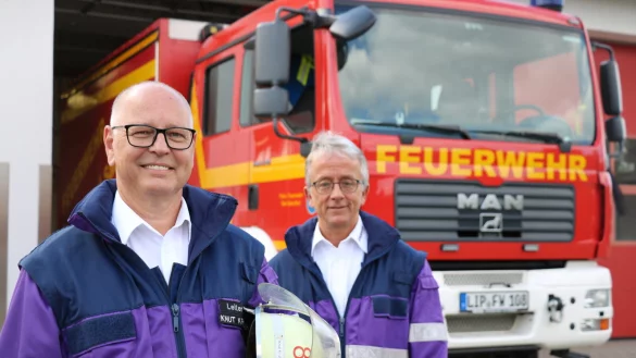 Knut Krutzsch (links) und Andreas Gronemeier von der Psychosozialen Unterst&uuml;tzung der Salzufler Feuerwehr stehen vor einem L&ouml;schfahrzeug am Ger&auml;tehaus in Lockhausen. - &copy; Alexandra Schaller