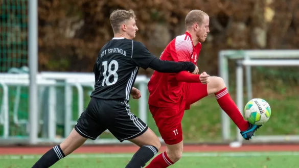 In dieser Szene nimmt der Blomberger Jarrit Karaus (rot, rechts) den Ball vor dem Postler Anton G&uuml;nter in der Luft an und treibt das Leder in Richtung Detmolder Tor. - &copy; Egon Penner