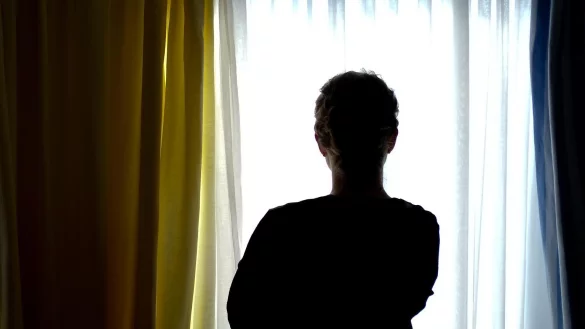 Frau steht vor Fenster - &copy; Foto: Peter Steffen/dpa