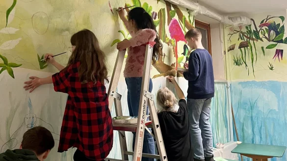 Schüler des Hermann-Vöchting-Gymnasiums bemalen gemeinsam mit Künstlerin Gaby Prasse den Flur des Landwirtschaftsgebäudes. - © Nina Schröder
