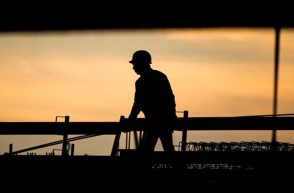 Ein Bauarbeiter in der Morgendämmerung. Laut Ifo-Beschäftigungsbarometer wollen viele Unternehmen Personal abbauen, in der Baubranche zeichnet sich jedoch keine größere Entlassungswelle ab. - © Julian Stratenschulte/dpa