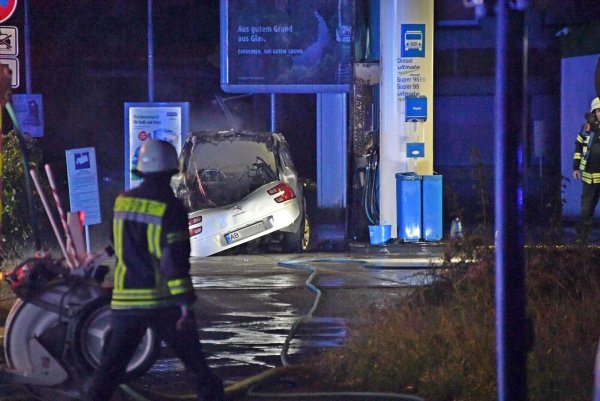 Ein ausgebranntes Autowrack steht an einer Tankstelle in Gütersloh. Die Polizei geht jetzt von einem Unglücksfall aus. - © Andreas Eickhoff/dpa